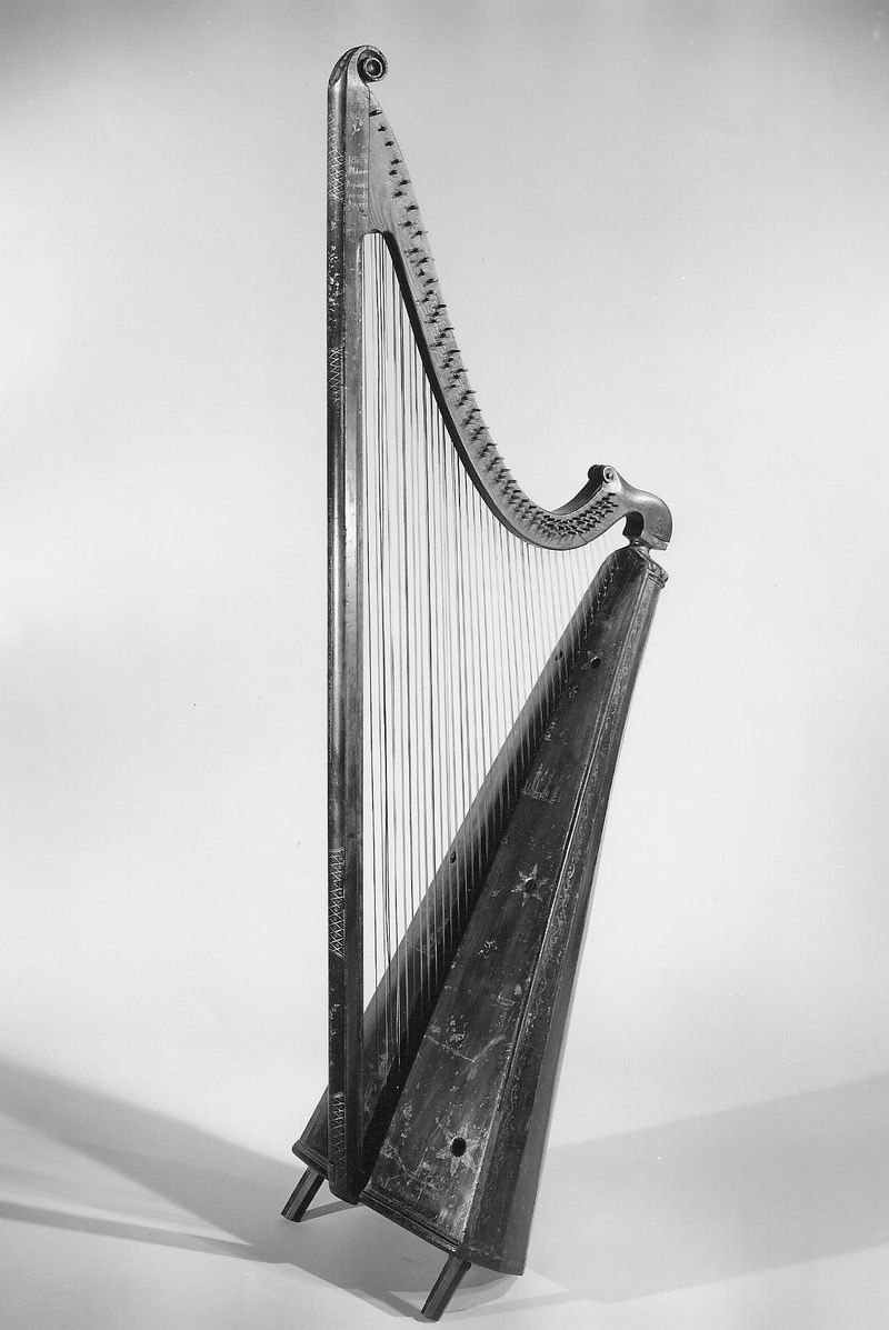 A tall Welsh triple harp with three rows of strings and a carved wooden neck and pillar